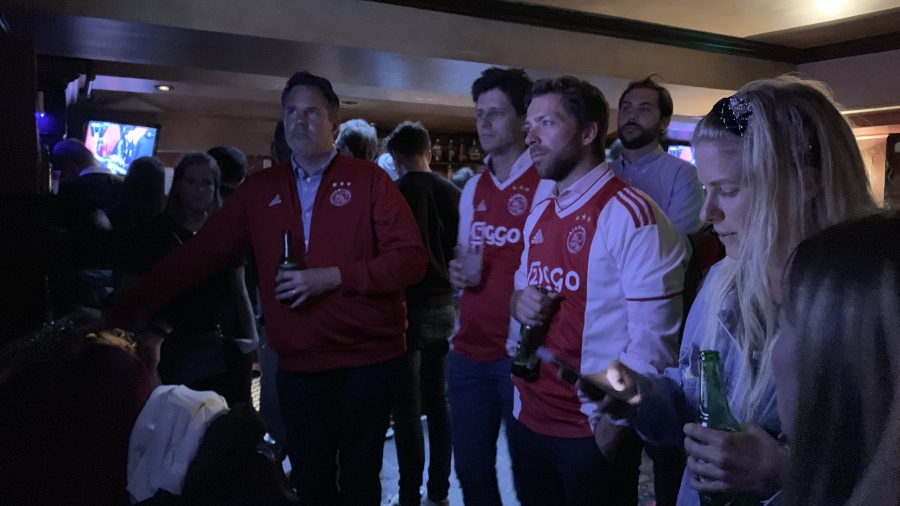 Ajax-fans kijken gespannen naar de wedstrijd.